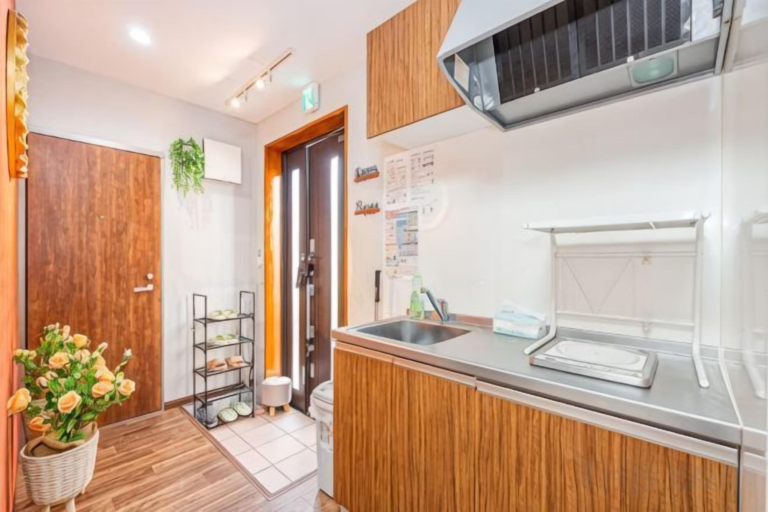 Una cocina con un armario de madera, un lavamanos y una ventana.