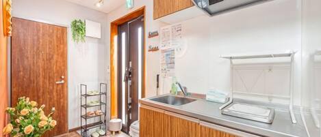 Una cocina con un armario de madera, un lavamanos y una ventana.