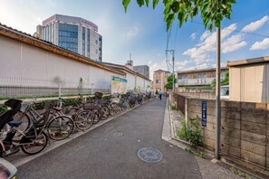 A bicycle lane with parked bikes, a manhole cover, and a building with a sign.