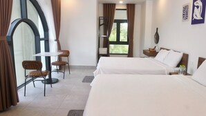 A hotel room with two beds, a small table, and chairs. - Monstera Hotel and Coffee (Phu Quoc)
