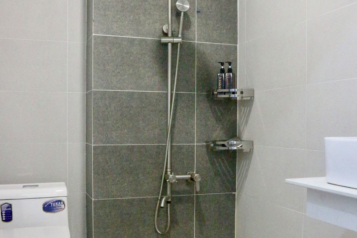 A modern bathroom with a shower, toilet, and sink.