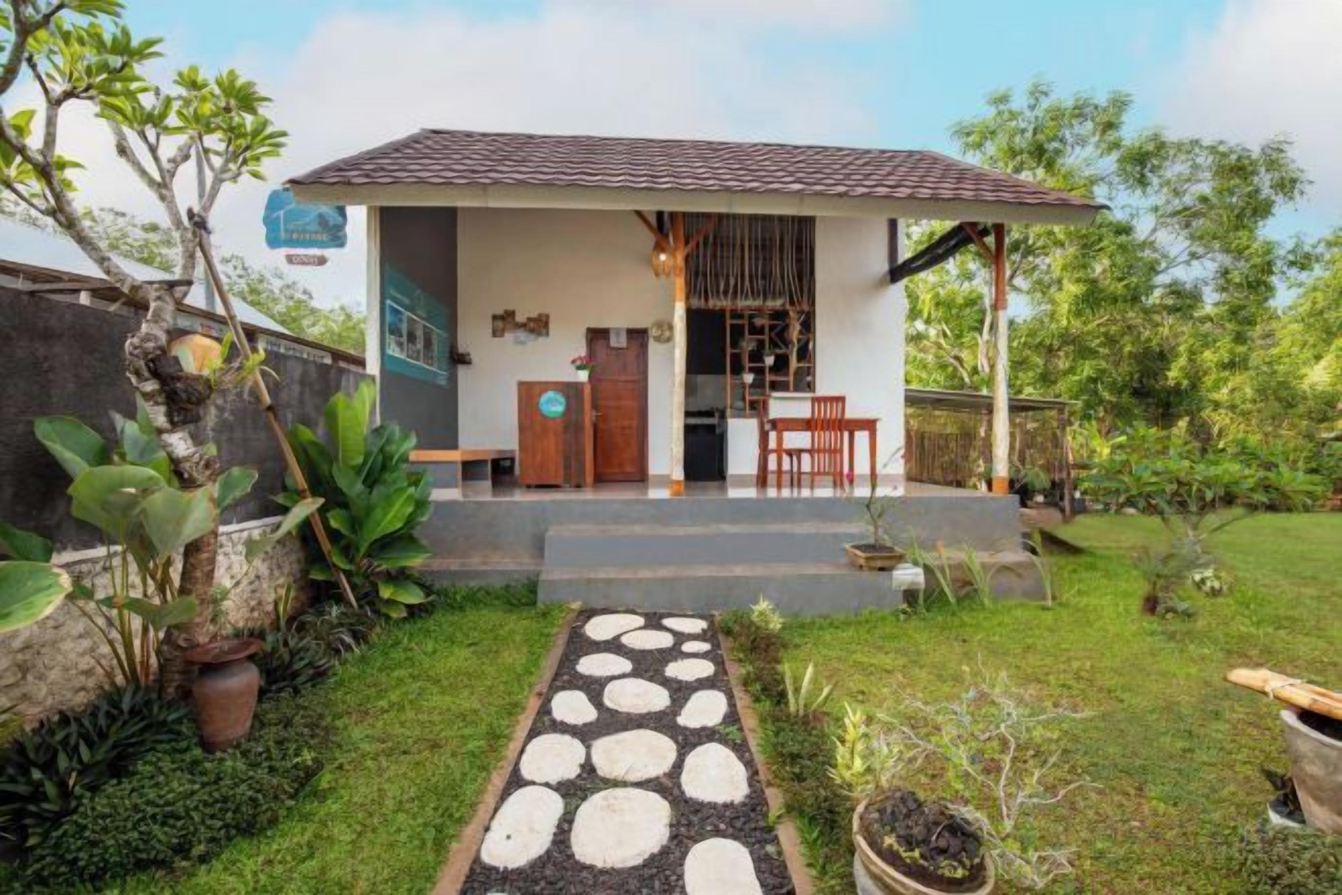 A house with a covered porch, a small garden with a stone pathway, and a door leading to the interior.