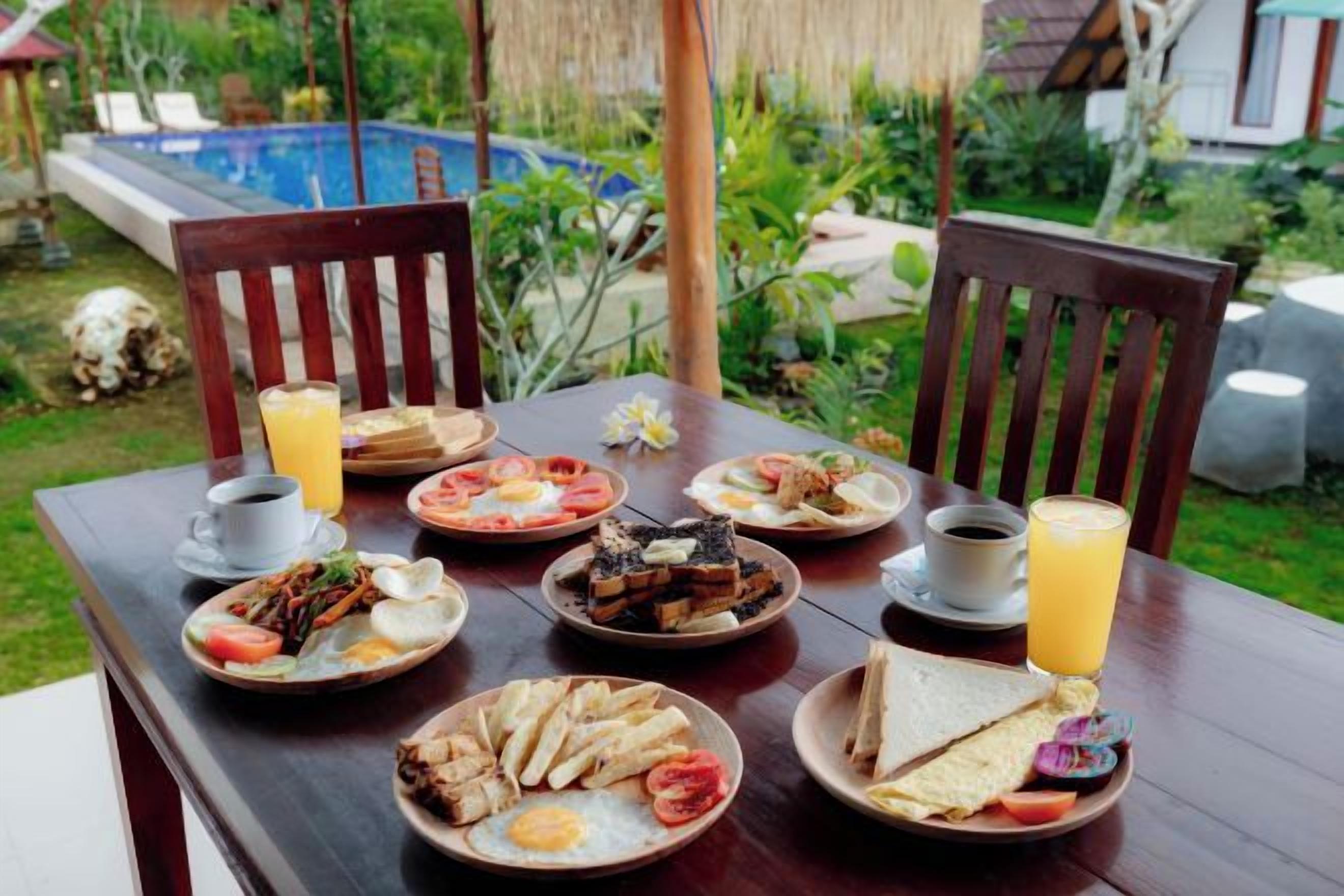 A wooden dining table set with plates of food, a glass of orange juice, and a cup of coffee.