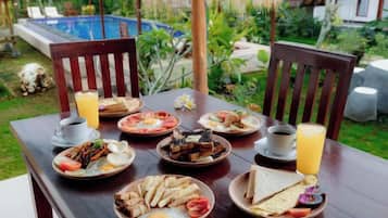 A wooden dining table set with plates of food, a glass of orange juice, and a cup of coffee.