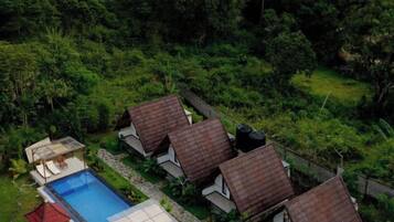 Un conjunto de casas con piscina y abundante vegetación.