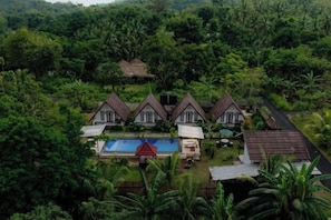 A resort with multiple bungalow-style buildings, a swimming pool, and lush greenery surrounding the property. - Maskot Penida Cottage (Bali)