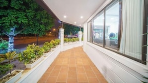 A covered outdoor area with a tiled floor, potted plants, and a view of a street at night. - Lam Anh Hotel 2 Duong Noi Ha Dong (Hanoi)