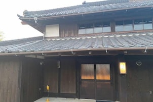 Un bâtiment japonais traditionnel, doté d’un toit recouvert de tuiles et de murs en bois.