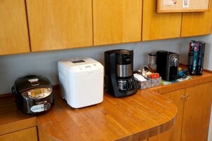 A kitchen counter with a coffee maker, a rice cooker, and a blender.
