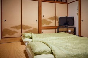 A room with a bed, a television on a stand, and a sliding door. - Malama Monstera - In a botanical space, pls have a relaxing time. (Isumi)
