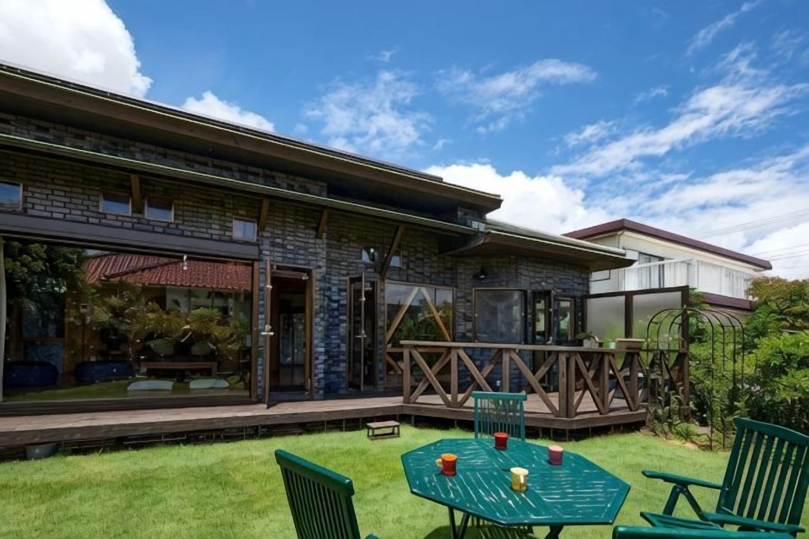 Een gebouw met een overdekt terras, buiten zitplaatsen en uitzicht op de lucht.