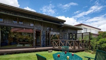 A building with a covered patio, outdoor seating, and a view of the sky.