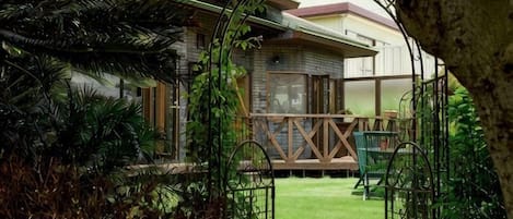 A house with a covered porch, a lawn, and a metal gate.