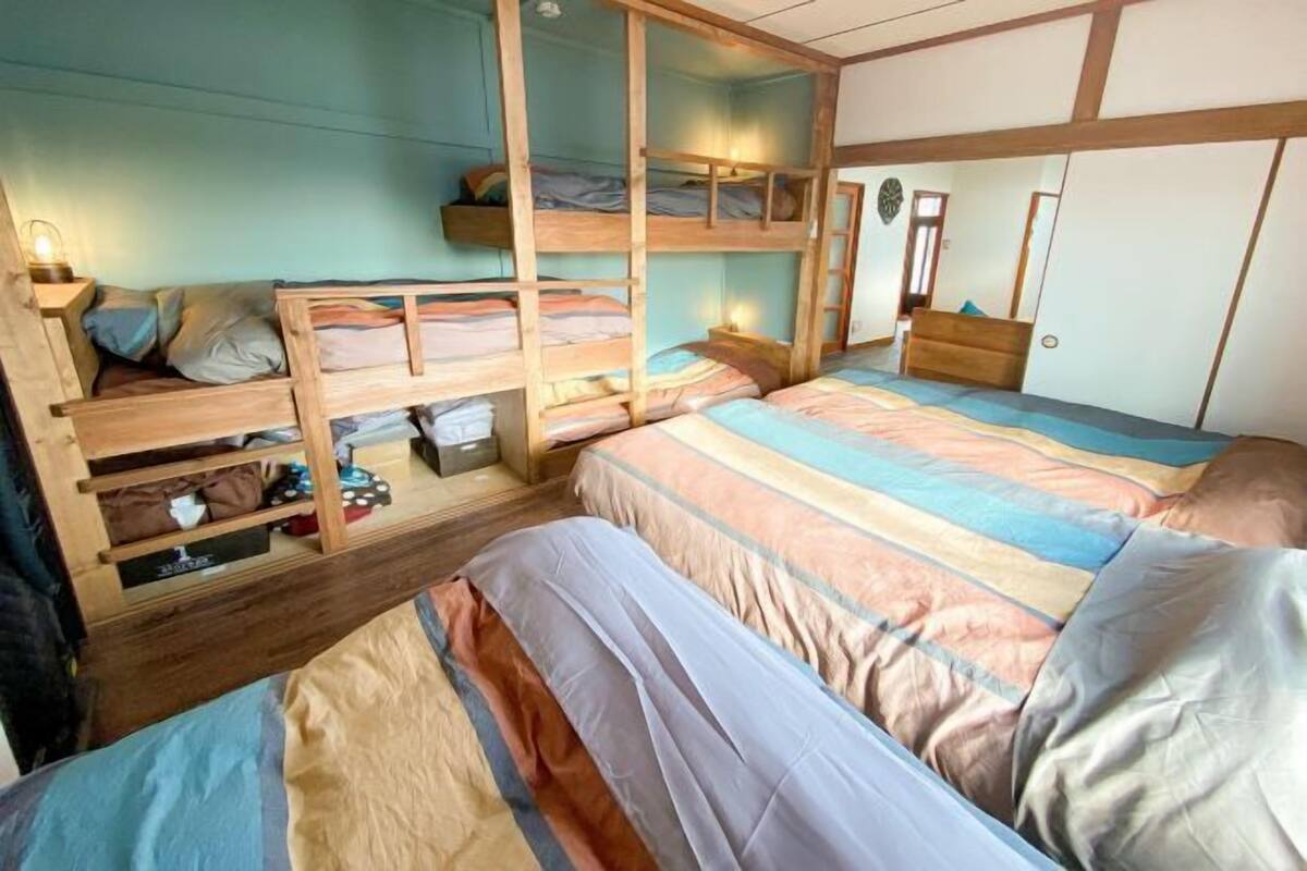 Ein Zimmer mit Etagenbetten, einem Holzschrank und einem Nachttisch mit Lampe.