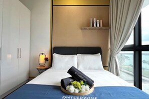 A hotel room with a bed, a nightstand, a lamp, a window with curtains, and a view of the outside. - Bora, Frelories Seaview Suite by Antlerzone (Johor Bahru)