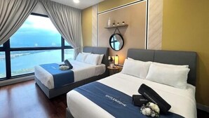 Une chambre d’hôtel avec deux lits, une grande fenêtre donnant sur un beau paysage, un ventilateur de plafond et un miroir fixé au mur.