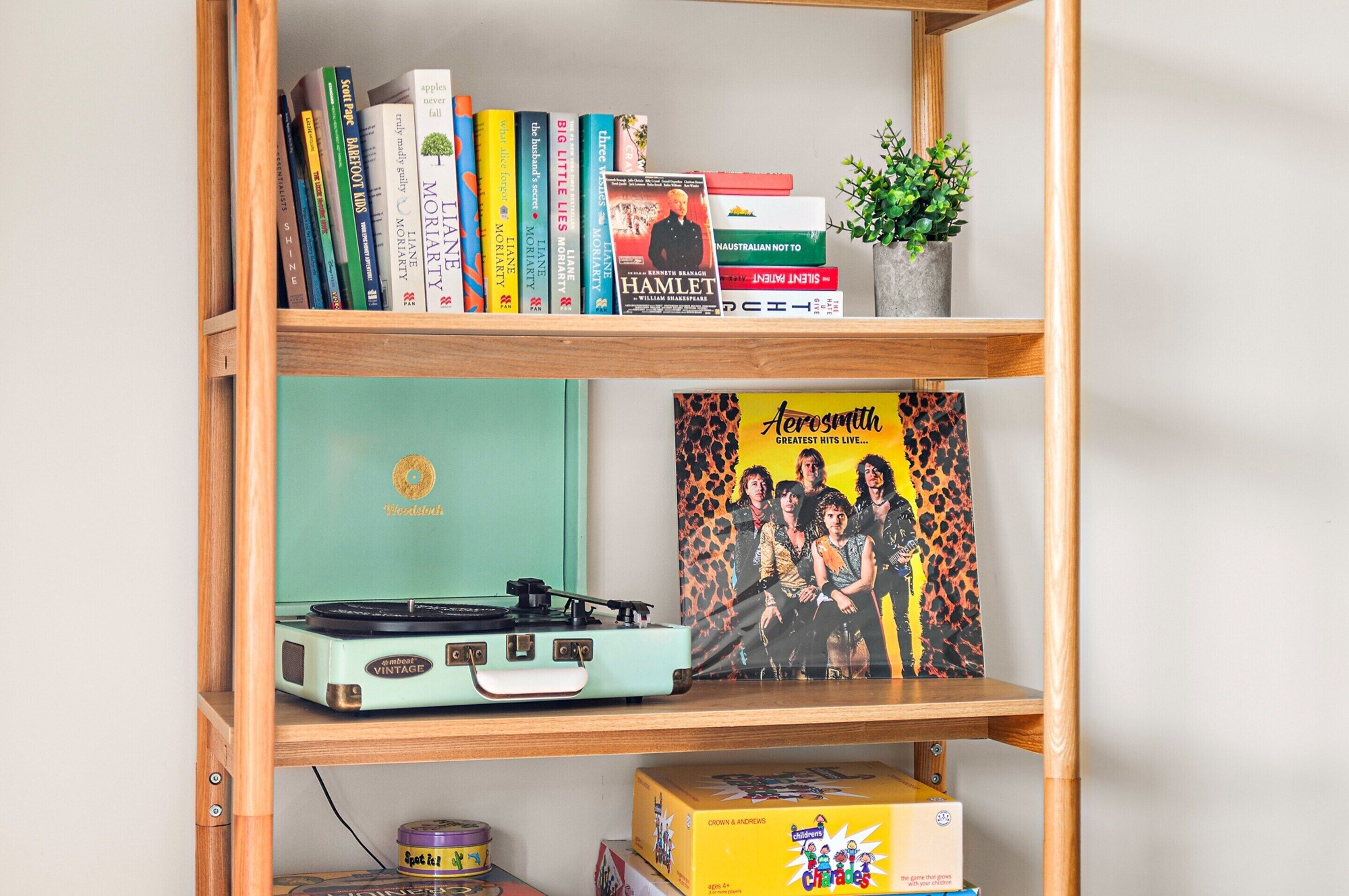 Ein Bücherregal mit verschiedenen Büchern, ein Plattenspieler und eine CD-Hülle.