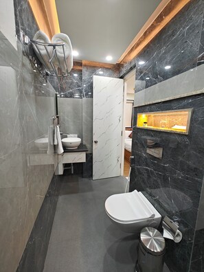 Une salle de bain moderne équipée de toilettes, d’un bidet et d’un lavabo.
