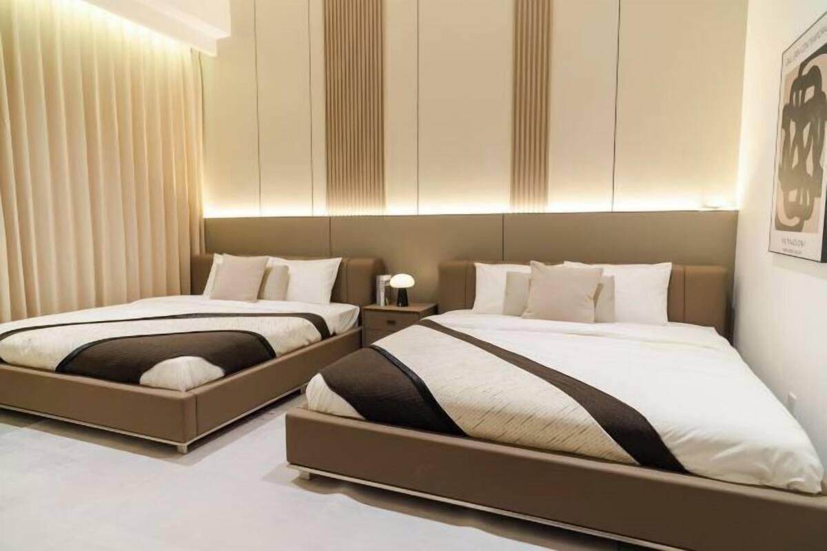 Ein Hotelzimmer mit zwei Betten, einem Nachttisch und einer Wandleuchte.