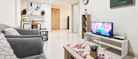 Ein modernes Wohnzimmer mit einer Couch, einem Fernseher und einem Couchtisch.