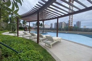 A rooftop pool area with lounge chairs and a pergola. - Lanting Hotel Apartment (Phnom Penh)