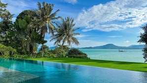 A clear view of a swimming pool with a view of the sea and mountains in the background. - 6BR Oceanfront Luxury Villa 30m Infinity Pool Villa Serenity Warm Plus (Phuket)