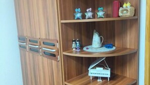 Un mueble de madera con tres repisas, cada una con varios objetos.