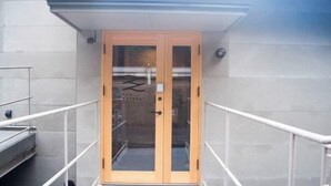 A modern building entrance with a glass door and a metal railing. - SEN.RETREAT TAKIJIRI (Tanabe)
