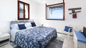 A bedroom with a bed, a chair, a desk, and a window with a view. - Respiro del Mare (Sorrento)