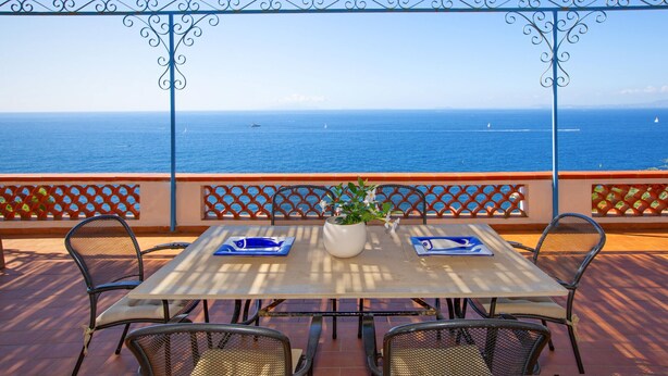 A table with chairs and a potted plant, overlooking the sea. - Respiro del Mare (Sorrento)