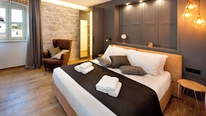 A modern bedroom with a large bed, a wooden chair, a stone wall, and a window with curtains. - Villa with pool und jacuzzi, 8 Persons, parking, near Porec (Nova Vas)