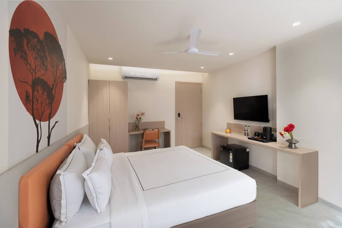 Ein modernes Hotelzimmer mit Bett, Schreibtisch, Fernseher und Klimaanlage.