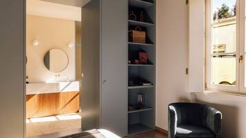 A bedroom with a bed, a wardrobe, a chair, and a window.
