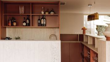 A modern kitchen with wooden shelves, a marble countertop, and a wooden floor.