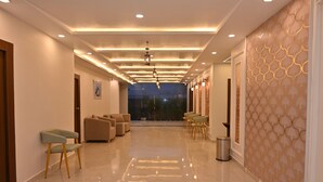 A hotel lobby with a long corridor, seating area, and a trash bin. - EcoXpress Satva Varanasi - Vegetarian with all Options (Varanasi)