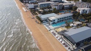 An aerial view of a coastal hotel with multiple buildings, a beach, and a swimming pool. - Rattanapura (Tha Mai)