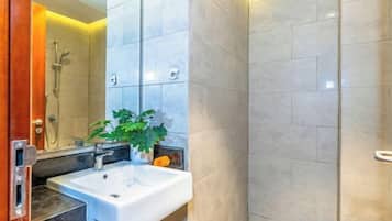 A bathroom with a sink, mirror, and shower.