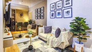Una sala de estar moderna con sofá, mesa de centro y plantas en macetas.
