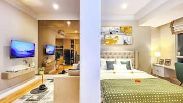 A modern hotel room with a bed, bedside table, lamp, and a flat-screen TV.