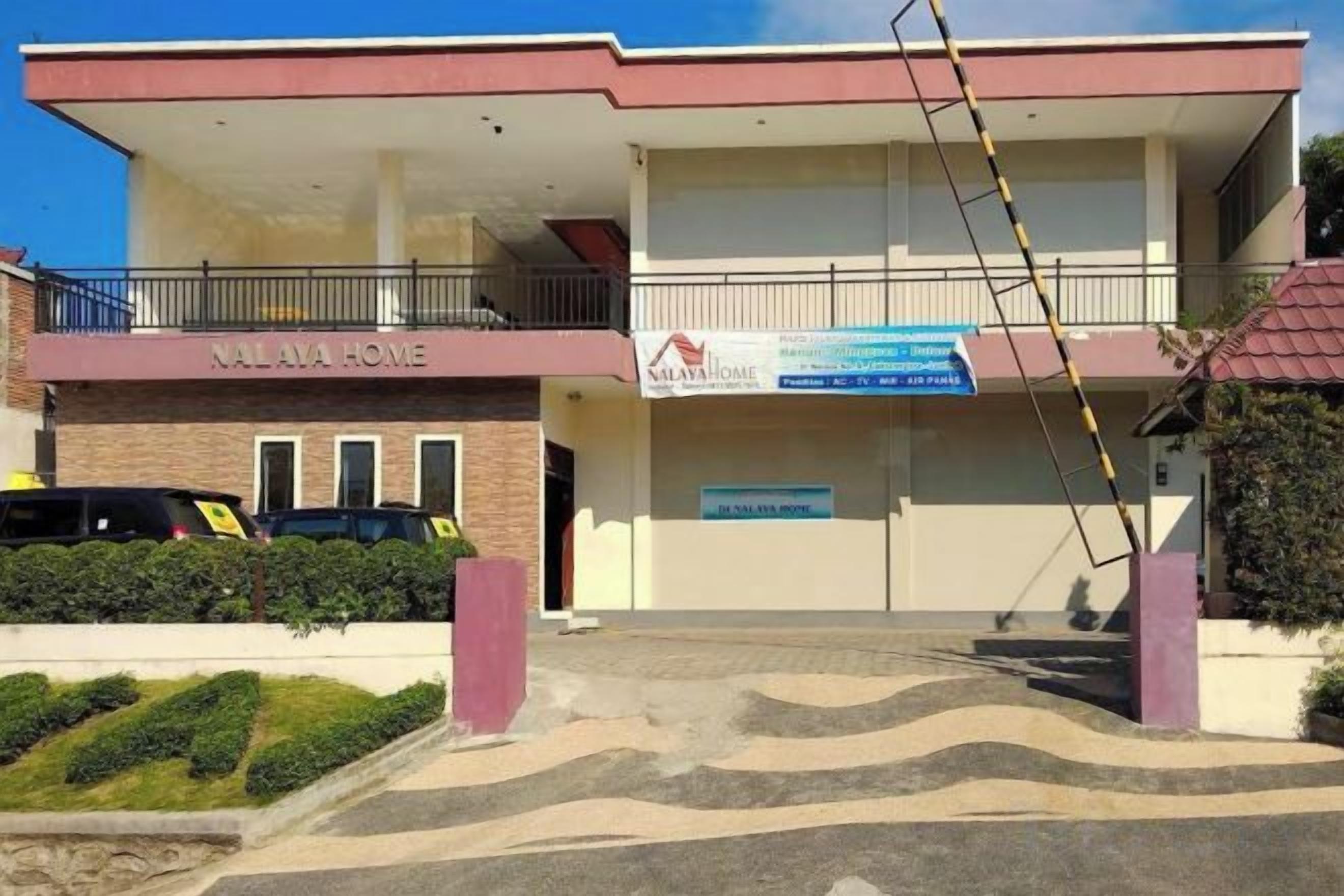A two-story building with a sign reading 'NALAVA HOME' and a banner advertising 'NALAVA HOME'.