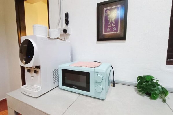 A microwave, a water dispenser, and a framed picture on a wall. - 57 Ruma Oren Heritage Jonker Residence (Melaka)