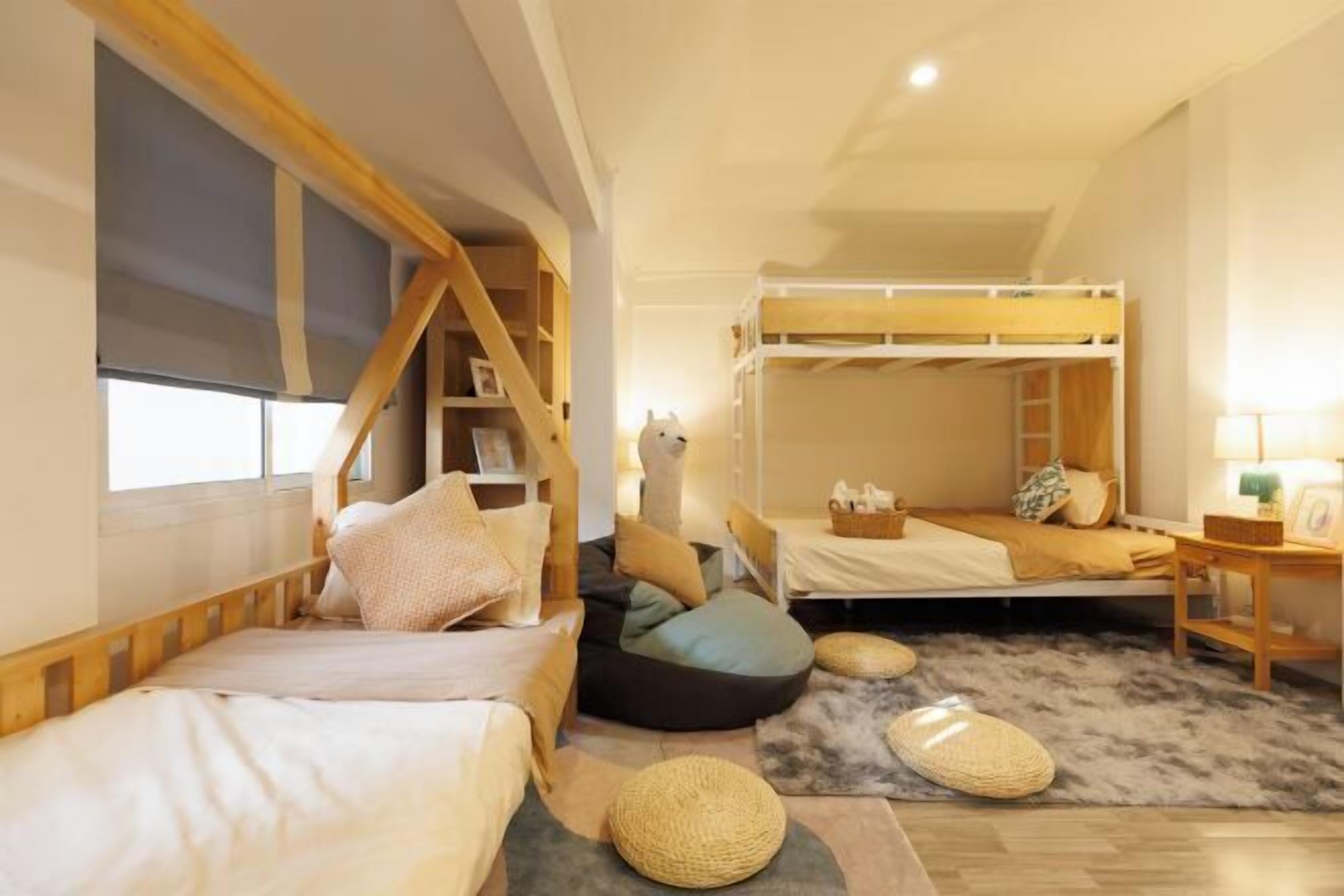 Une chambre confortable avec des lits superposés, une bibliothèque en bois et un tapis moelleux.