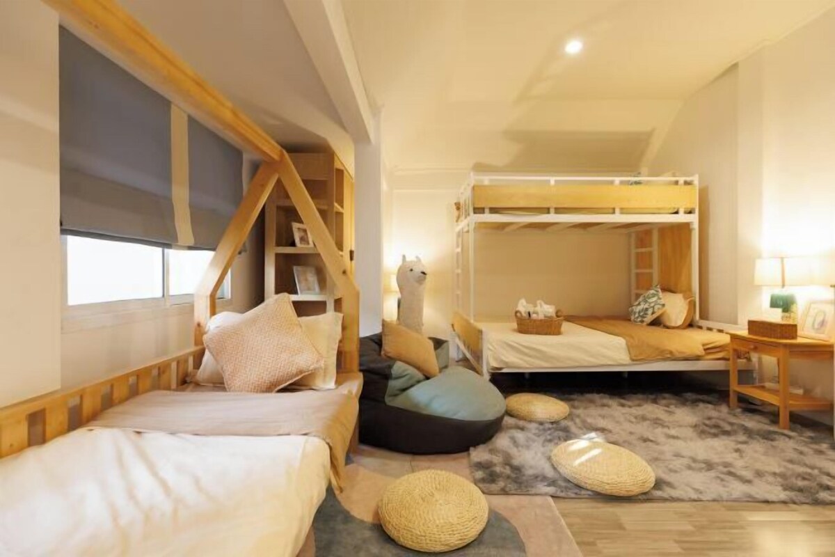 A cozy bedroom with bunk beds, a wooden bookshelf, and a fluffy rug.