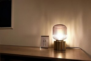 Ein Tisch mit einer Lampe und einem gerahmten Bild darauf.