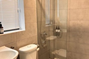 A bathroom with a glass-enclosed shower, a toilet, and a sink. - Saigon Holiday House (Ho Chi Minh City)