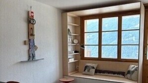 A room with a built-in bench with shelves, a table with chairs, and a window with a view. - Outside: Bright and warm apartment, facing south, with furnished terrace and exceptional view of the (St-Luc)