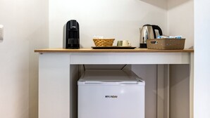 Eine Küchenzeile mit Kaffeemaschine, einem Korb und einem Wasserkocher auf einer Holzausziehtafel.