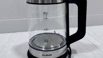 Een transparante elektrische waterkoker met aanduidingen voor de hoeveelheid en een zwarte handgreep.