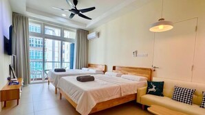 A hotel room with two beds, a sofa, a TV, and a balcony with curtains. - Riverine Diamond Rda12 Studio CK - Free 1 Parking, Netflix & Cozy Retreat Couples, Families (Kuching)