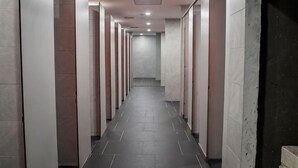 A long, narrow hallway with multiple doors on one side, leading to individual rooms. - Riverine Diamond Rda12 Studio CK - Free 1 Parking, Netflix & Cozy Retreat Couples, Families (Kuching)